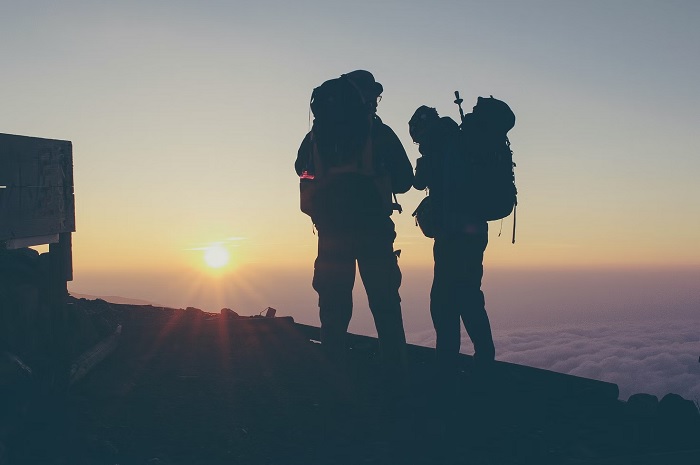 Silhouette of two hikers on a mountain top a dusk