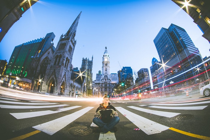 Long exposure picture of man sitting on a zebra crossing