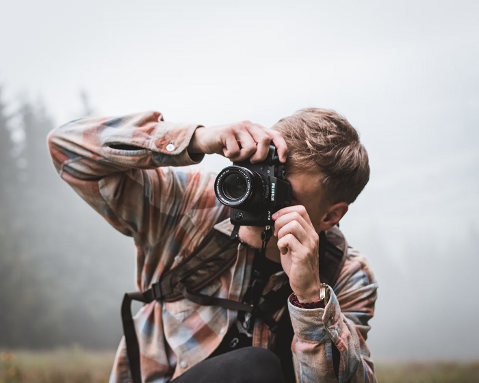 Young man taking a photo with a Fujifilm camera