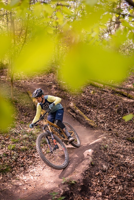 Action shot of a mountain biker riding downhill in a forest shot with one of the best canon camera for sports photography
