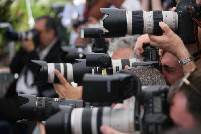 A crowd of press photographers seen from the side