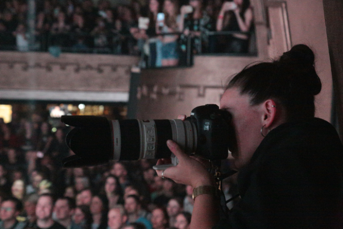 Photographer with telephoto lens in a theatre