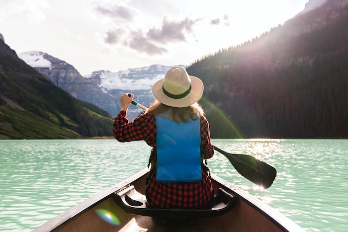 woman in canoe on a lake shot with one of the best budget travel camera options