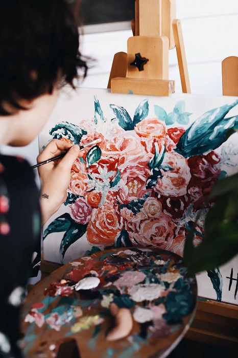 Artist paint flowers on a canvas