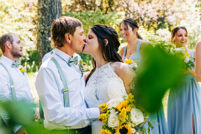 A couple's first kiss at a wedding reception outdoors