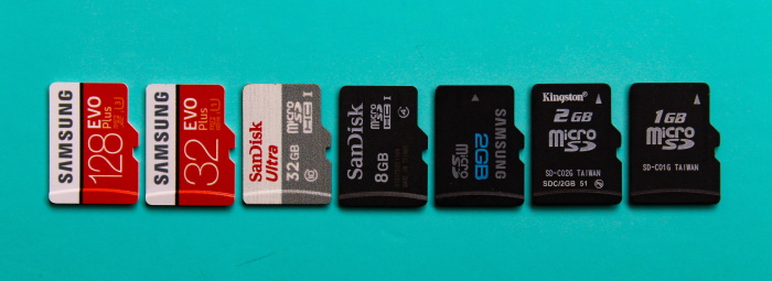Types of camera memory cards in a line against a turquoise green background