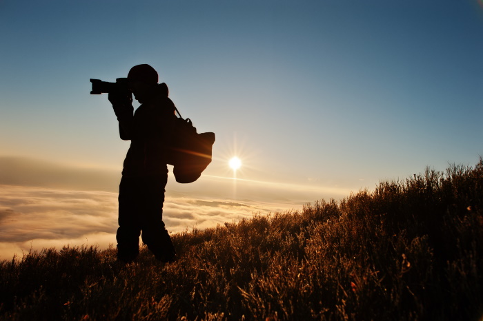 Silhouette of a professonal photographer taking photos outdoors