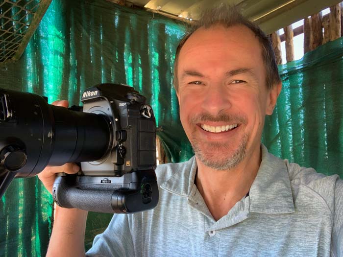 Wildlife photographer Nick Dale holding a Nikon cameras and lens