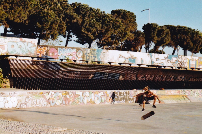 Action shot of a skateboarder doing a flip trick in an outdoor skate park