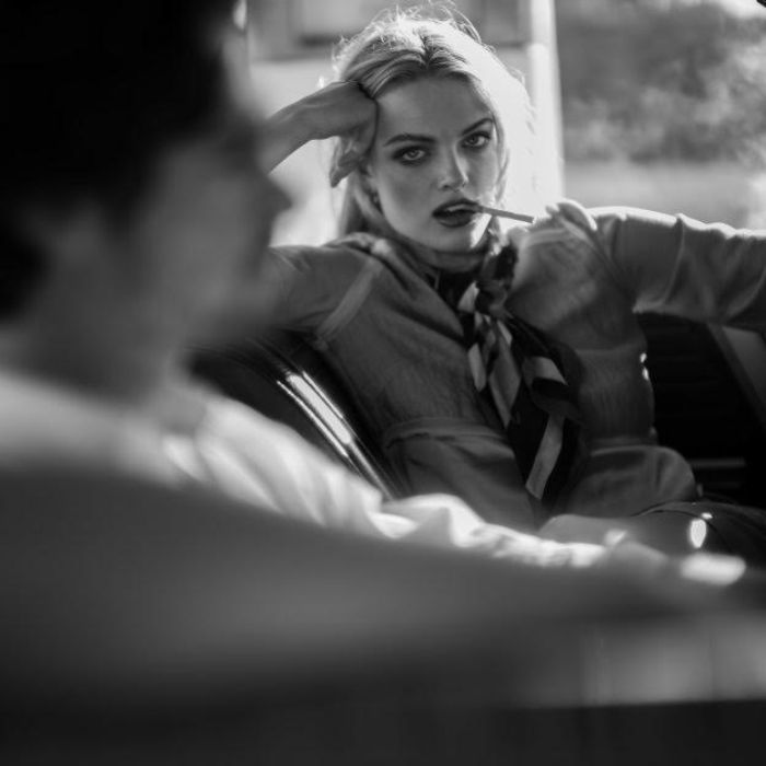 Black and white portrait of a woman (and man out of focus) on a sofa