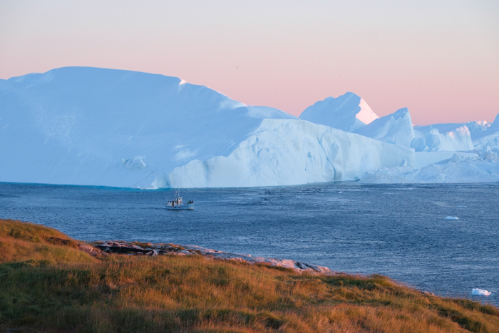 Landscape and seascape photo of a boat in water in Greenland
