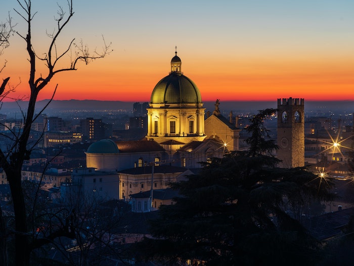 Church dome and cityscape with lights coming on at dusk