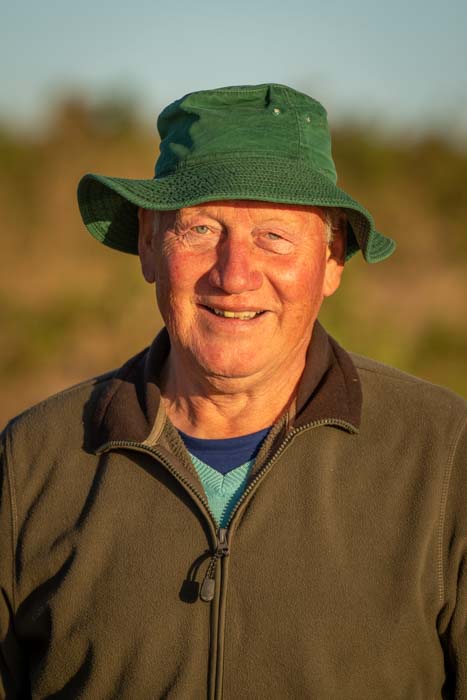 Portrait of an older man in hat with sunlight on his reddened face