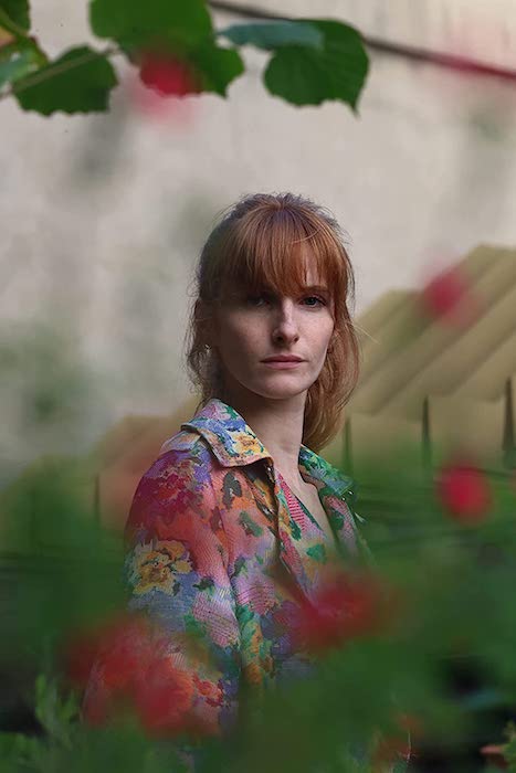 Portrait of a woman surrounded by plants, taken with the Canon EOS R8