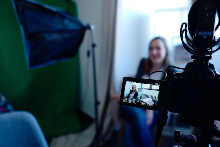 A camera with flip screen out recording a woman vlogging