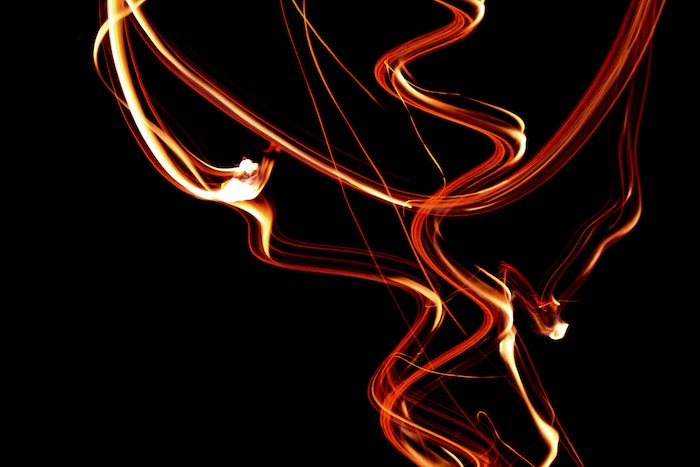 Curved and squiggly red and yellow lights against a black background