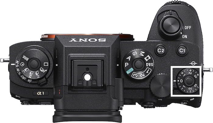 Top-view product image of a Sony a1 with the exposure compensation dial highlighted with a white box