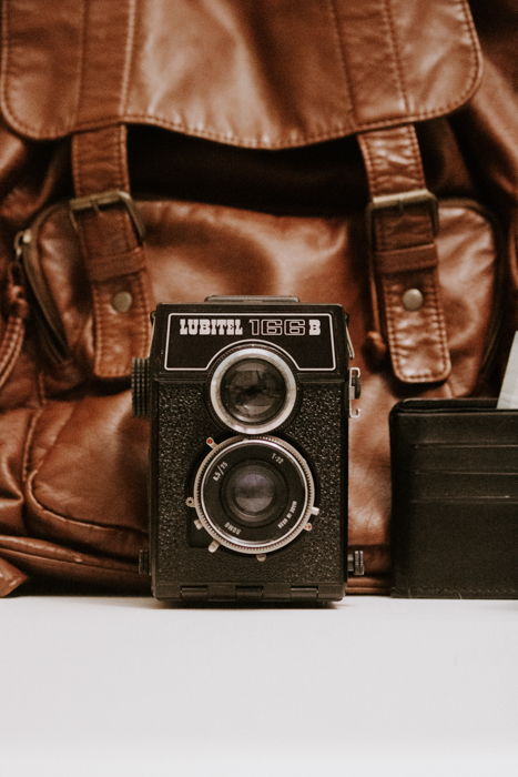 finding camera manuals online: a lubitel 166 film camera sitting in front of a brown leather bag