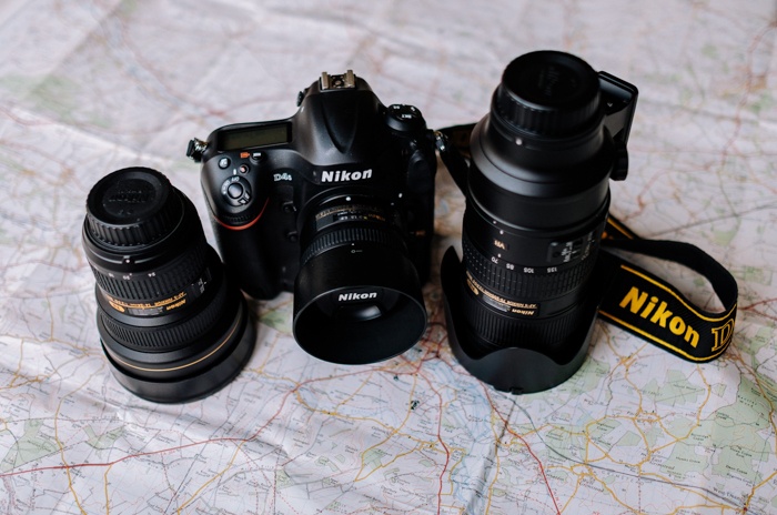 a Nikon dslr camera and two lenses sitting on a map
