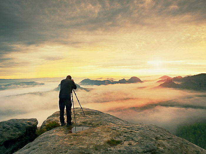 A man shooting images of fog in a landscape