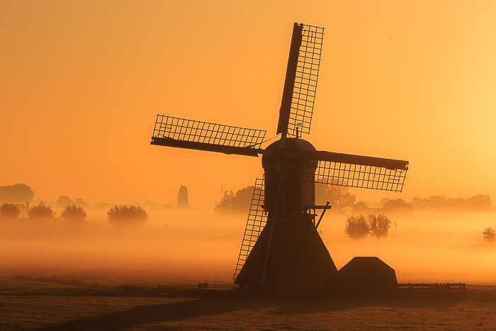A windmill in a foggy landscape