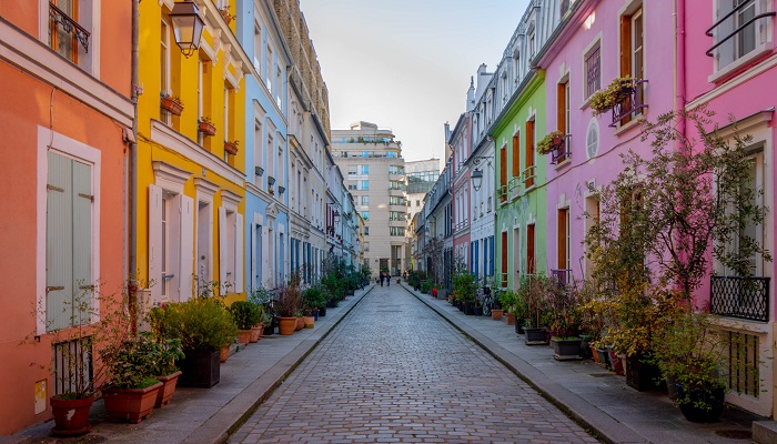 An empty residential street in Paris with colorful apartment buildings on either side